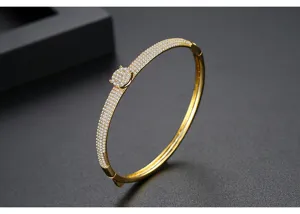 Primer plano detallado de brazalete chapado en oro con micropavé total de circonitas