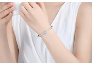 Elegante brazalete plateado con pavé de circonitas brillantes en la muñeca.