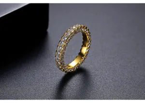 Primer plano detallado de un anillo de latón dorado con circonitas blancas engastadas.