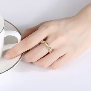 Elegante anillo de eternidad con circonitas cúbicas en latón chapado en oro en la mano