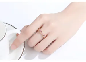 Detalle de un anillo chapado en oro con circonitas rosas talla marquise puesto en el dedo