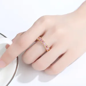 Elegante anillo chapado en oro con circonitas marquise rosas en la mano de mujer