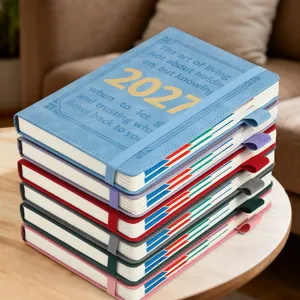 Pile d'agendas quotidiens anglais 2027 colorés avec bandes élastiques sur table.