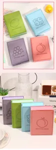 Sammlung von vier bunten Notizbüchern mit Früchtemotiven in einer Lifestyle-Umgebung