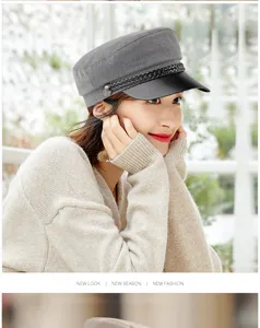Stylish grey flat-top fiddler hat with black leather brim worn by an Asian model