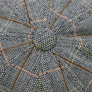 Detailed top view of a classic grey herringbone newsboy cap featuring an orange grid pattern