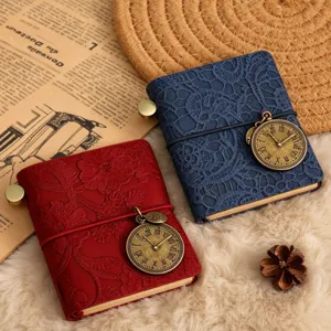 Mini carnet vintage en dentelle avec bande élastique et pendentif horloge ancienne.