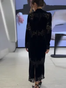 Elegante zwarte fluwelen maxi-jurk met verfijnd kantwerk op de rug en zoom.