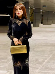 Elegante zwarte fluwelen maxi-jurk met verfijnde kanten details bij de hals en mouwen.