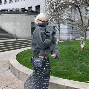 Dettaglio giacca in lana grigia con collo alto, stile cappotto invernale casual.