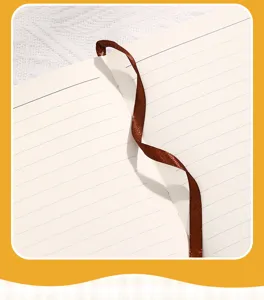 Macro view of premium cream lined notebook pages with a silk brown ribbon bookmark