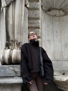 Giacca cappotto in lana nera ampia da donna con collo a imbuto, perfetta per autunno e inverno.