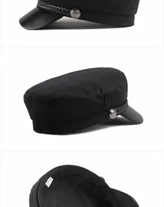 Detailed views of a black baker boy cap with leather brim and crest buttons
