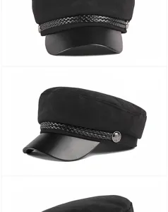 Detailed macro shot of a black wool baker boy hat with faux leather brim and braided cord