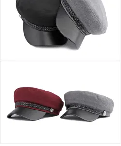 Detail of fashionable wool flat top caps with braided band in black, grey and burgundy