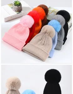 Dettaglio di berretti in maglia colorati con pon pon in finta pelliccia per l'inverno
