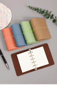 Detalle de mini carpetas de cuero Morandi en varios colores con mecanismo de 5 anillos