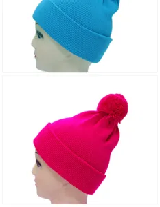 Primo piano di berretti colorati in maglia acrilica con pompon e risvolto.