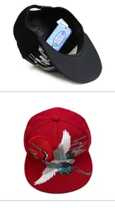 Detailansicht der roten und schwarzen Baseballkappen mit Kranich-Stickerei