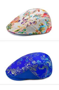 Detailed view of two ethnic style embroidered flat caps with floral and dragon patterns.