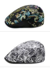 Detailed view of two ethnic style flat caps with dragon embroidery and tiger print