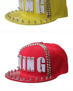 Dettaglio di cappelli snapback hip-hop con lettere KING in acrilico e borchie punk.