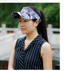 Female model wearing a stylish camouflage sun visor hat in an outdoor park setting