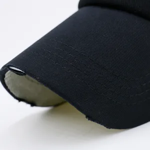 Detailopname van zwarte baseballpet met gerafelde rand en strakke stikseldetails