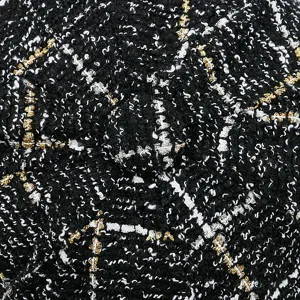 Primer plano de una boina vintage de tweed con textura de cuadros negro y oro