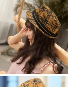 Detail of retro plaid fedora hat with graffiti letters and decorative zipper.