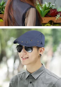 Detailed view of a stylish navy blue flat cap with metal rivet details on a male model