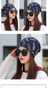 Detailed view of a navy blue winter turban hat with colorful feather prints on model