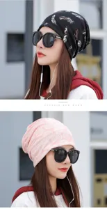 Detailed view of women's patterned beanie hats in black feather and pink leaf designs.