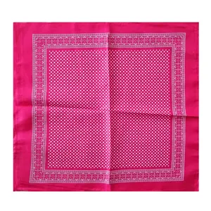Vista detallada de una bandana cuadrada magenta con un patrón de lunares blancos y borde
