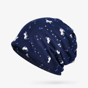 Detailed view of navy blue slouchy beanie with white cat and paw print pattern.
