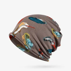 Detailed view of a soft brown slouchy beanie hat featuring vibrant feather prints
