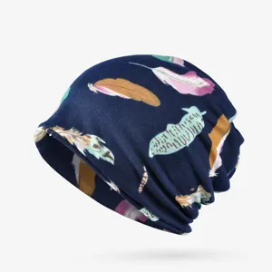 Close-up of navy slouchy beanie hat featuring a colorful feather print and soft fabric