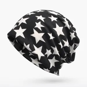 Close-up detail of a soft black knitted beanie featuring a trendy white star print pattern