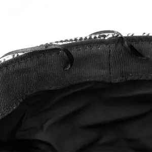 Close-up of black and white plaid beret hat showing adjustable inner lining ribbon