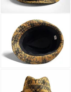 Close-up detail of yellow plaid fedora hat with black graffiti print and soft lining