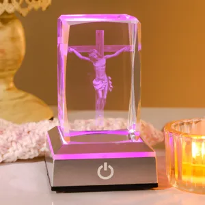 Gros plan d'une veilleuse en cristal Jésus gravée au laser 3D avec socle LED lumineux