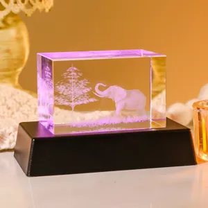 Primer plano de un bloque de cristal grabado en 3D con elefante sobre base LED luminosa