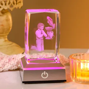 Nahaufnahme eines 3D-lasergravierten Kristallwürfels mit Kommunion-Design und pinkem LED-Licht