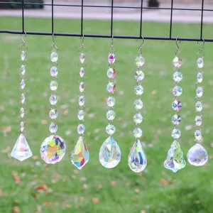 Detailed shot of seven diverse crystal suncatcher prisms hanging in a garden setting