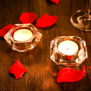 Bougeoirs élégants en cristal européen sur bois sombre avec des pétales de rose rouges