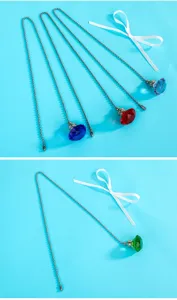 Detailed view of colorful diamond crystal ceiling fan pull chains on blue background