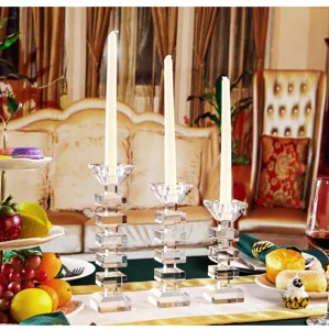Detailed view of three modern crystal candle holders arranged on an elegant dining table