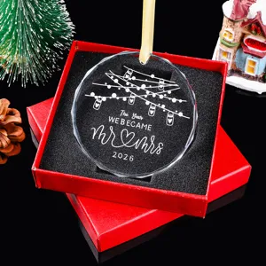 Detail van gegraveerd 'Mr & Mrs 2026' kerstornament in een rode geschenkdoos