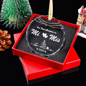 Detail van het ronde glazen 'Our First Christmas' ornament in een rode geschenkdoos