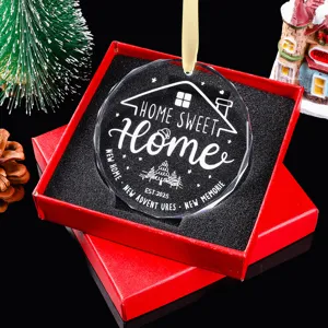 Detail van het gegraveerde kristallen Home Sweet Home 2025 ornament in een rode cadeauverpakking.